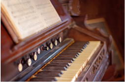 Picture of an old piano with sheet music, open and ready to play
