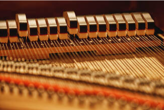 Picture of the internal mechanisms of a piano showing the strings and hammers